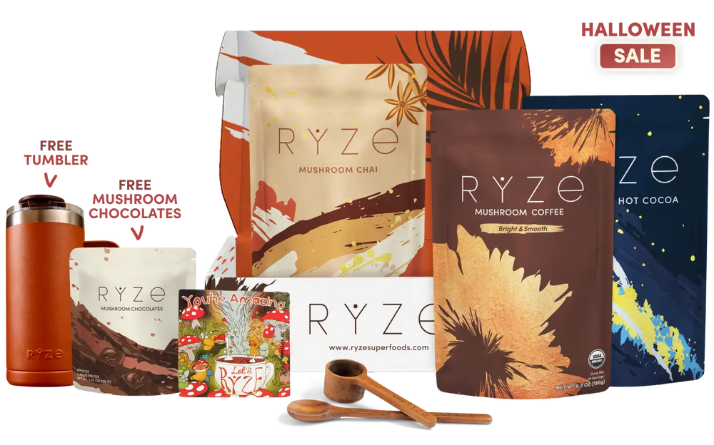 A RYZE gift set displayed on a white background with promotional text. The set includes a large box of Mushroom Chai, a pouch of Mushroom Coffee, a blue pouch of Hot Cocoa, a tumbler, a chocolate bar, a small magnet, and two wooden measuring spoons.